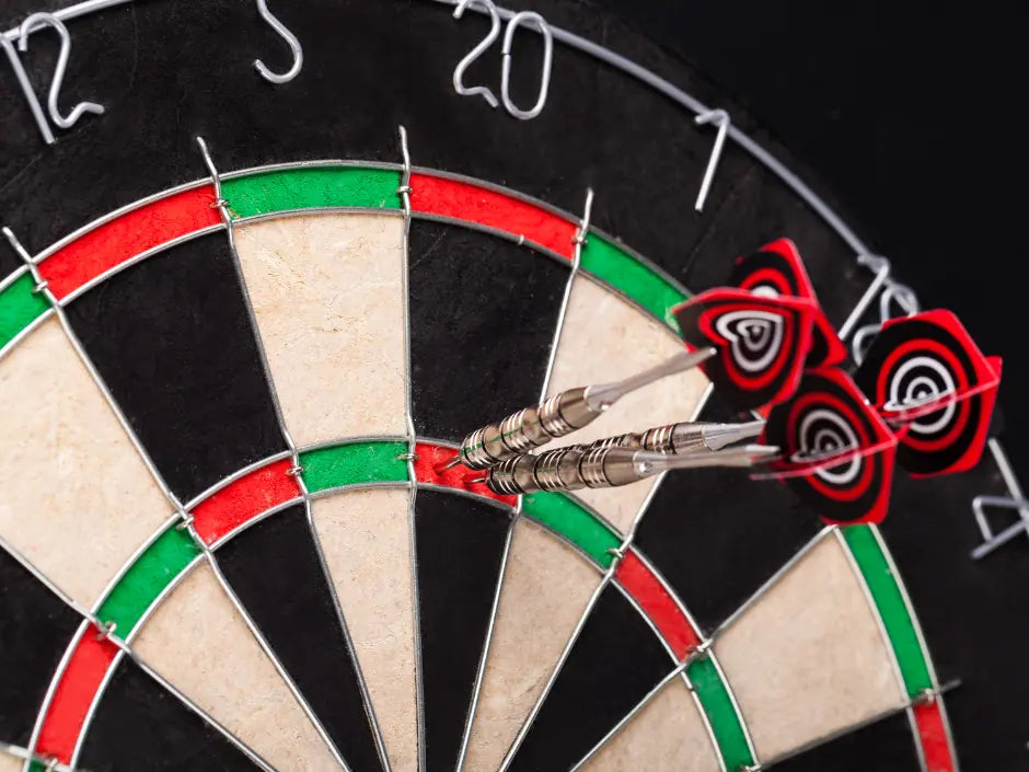 Darts with black and red Robson Plus flights grouped in a dartboard